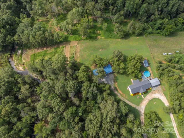 an aerial view of lake residential house with outdoor space and trees around