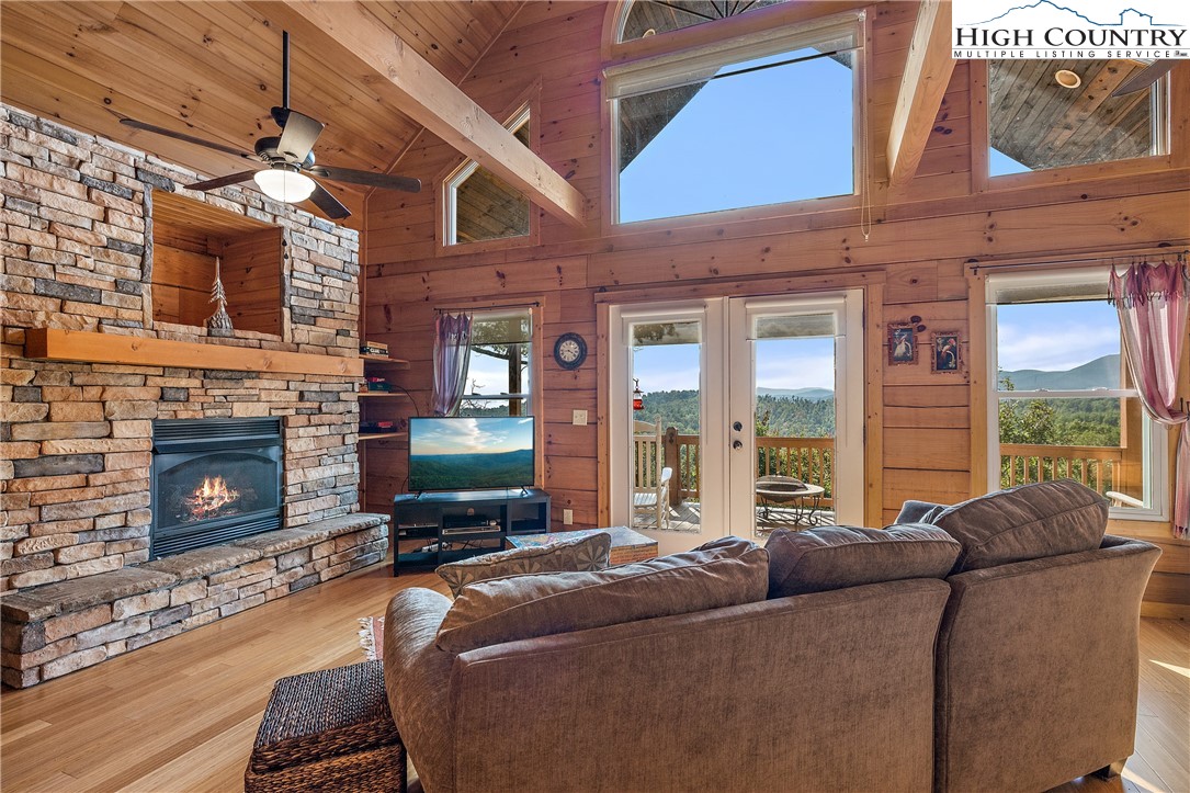 4923 Staghorn Road Purlear, NC 28665 - Photo 13 of 49 a living room with furniture a fireplace and a floor to ceiling window