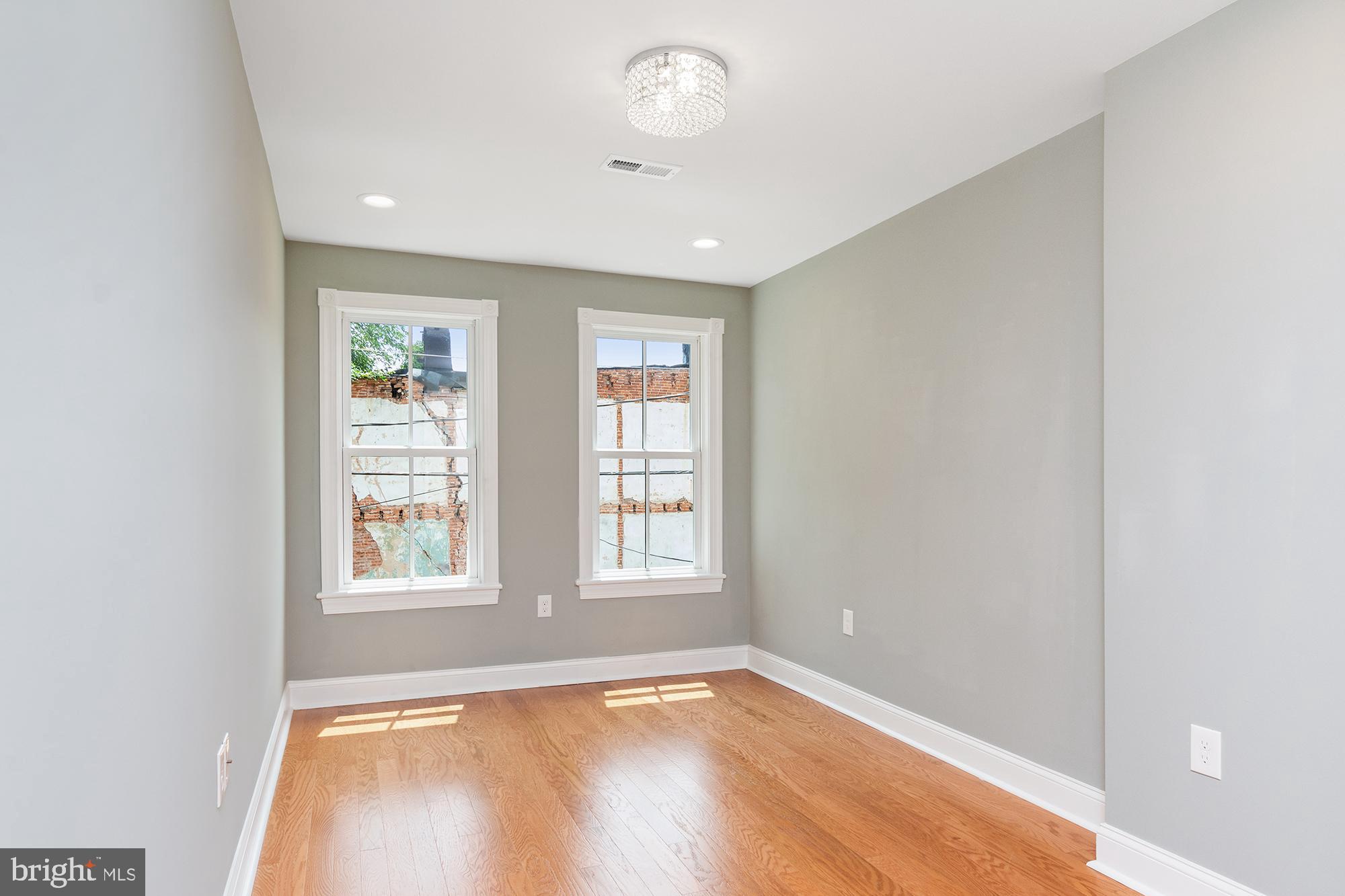 1429 Federal Street Baltimore, MD 21213 - Photo 2 of 5 an empty room with wooden floor and windows