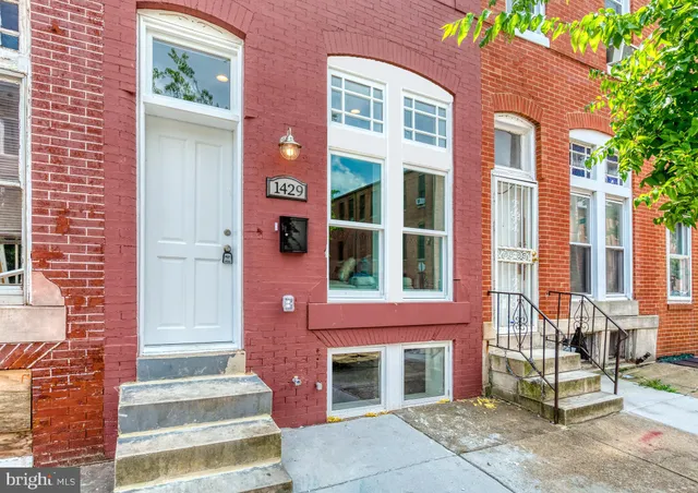 a front view of a brick building with large windows