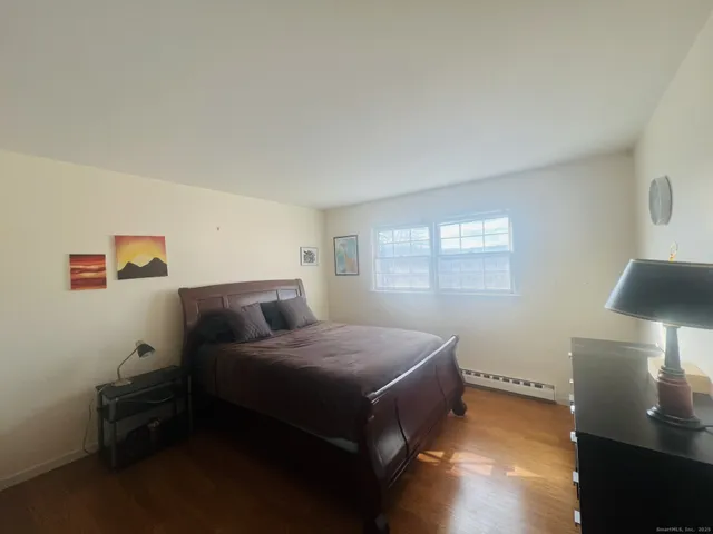 a spacious bedroom with a bed and a lamp