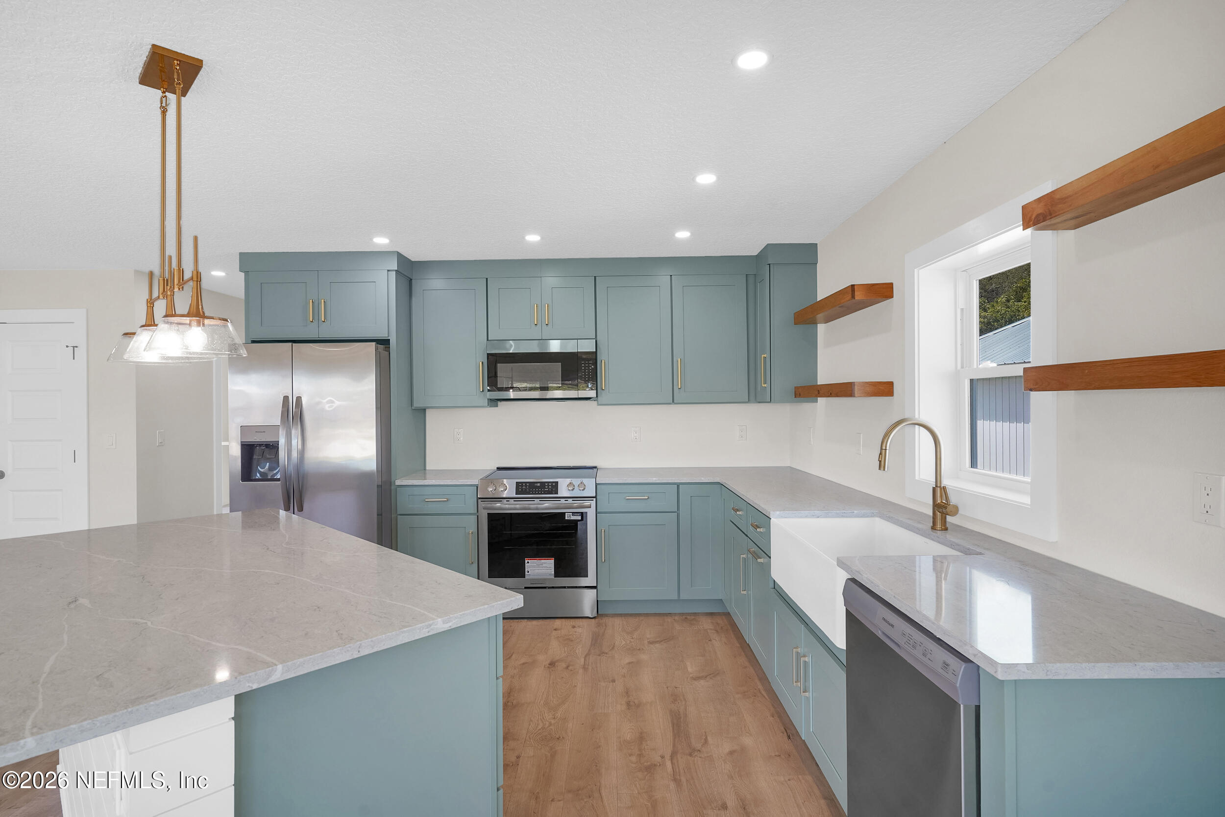 1132 5th Street St. Augustine, FL 32095 - Photo 11 of 34 a large kitchen with stainless steel appliances granite countertop a sink a stove and a refrigerator