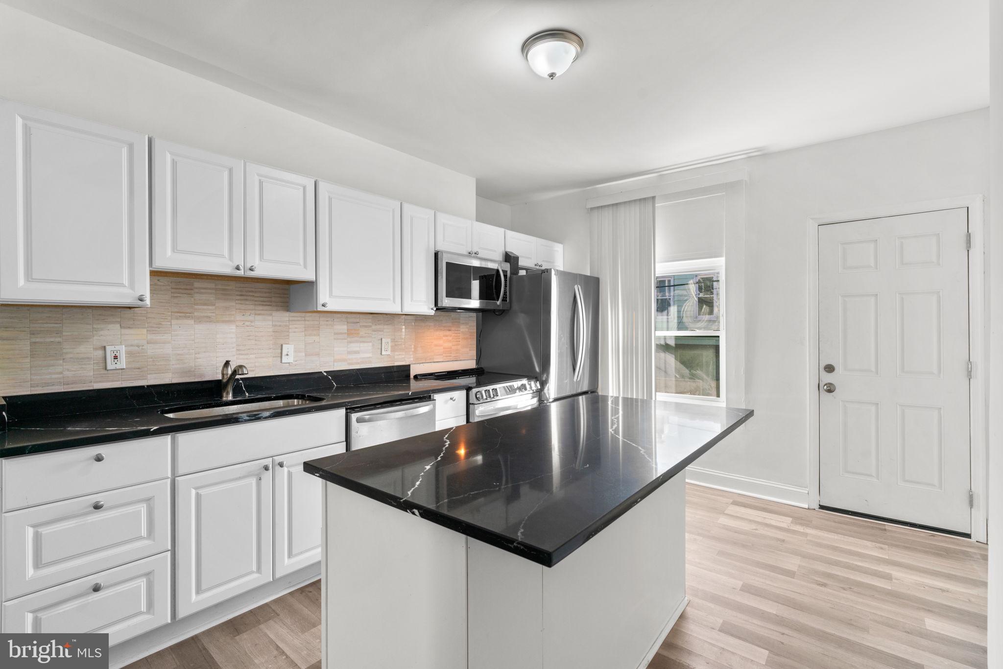 1731 Cliftview Avenue Baltimore, MD 21213 - Photo 11 of 33 a kitchen with granite countertop a sink a center island and cabinets