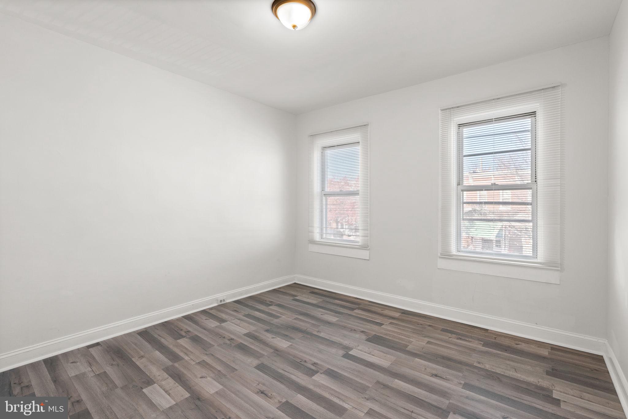 1731 Cliftview Avenue Baltimore, MD 21213 - Photo 21 of 33 an empty room with wooden floor and windows