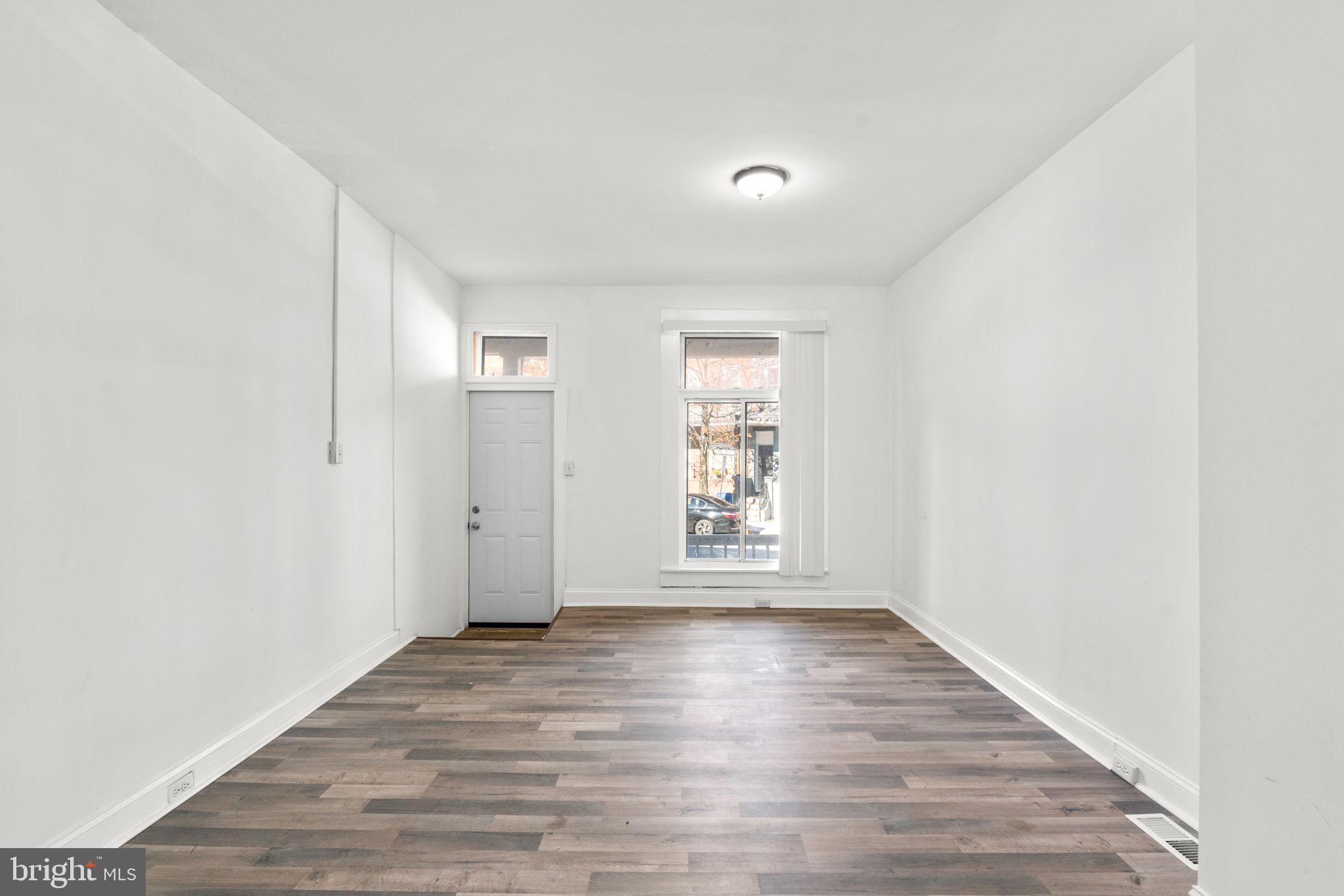 1731 Cliftview Avenue Baltimore, MD 21213 - Photo 6 of 33 an empty room with wooden floor and windows