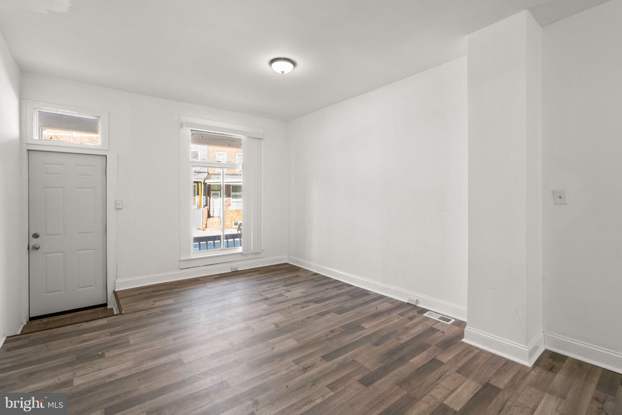 1731 Cliftview Avenue Baltimore, MD 21213 - Photo 7 of 33 an empty room with wooden floor and windows