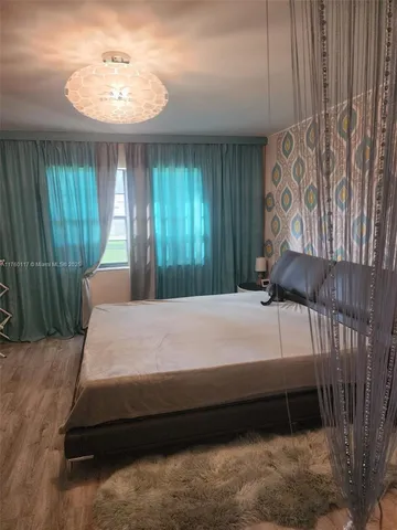 a bedroom with a bed and a chandelier