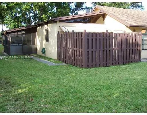 a view of backyard with small cabin and wooden fence