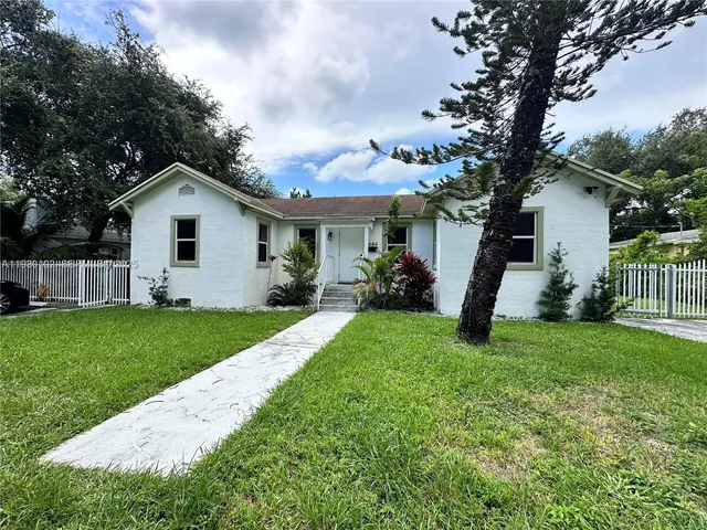 a view of a house with a yard and tree s