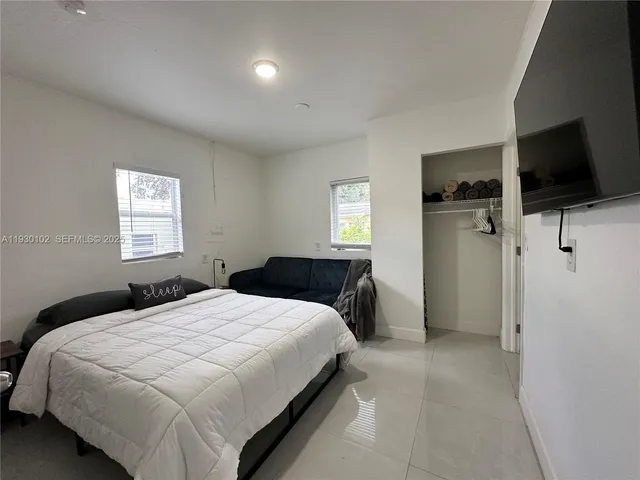 a bedroom with a bed and a flat screen tv