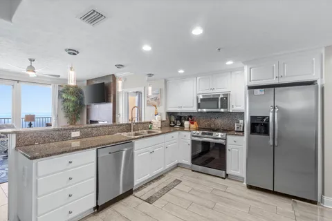 a living room with lots of furniture and kitchen view