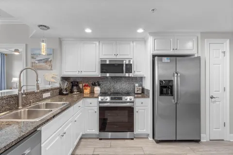 a kitchen with stainless steel appliances granite countertop a sink stove and microwave
