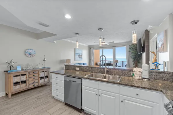 a kitchen with granite countertop a sink stainless steel appliances and a counter space