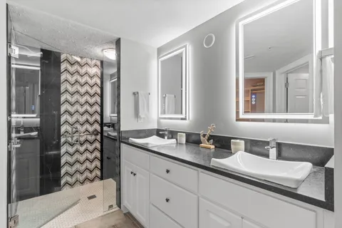 a bathroom with a sink a large mirror and a shower