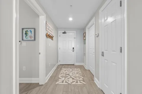 a view of a hallway with wooden floor and staircase