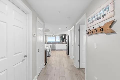 a view of a hallway with wooden floor and closet