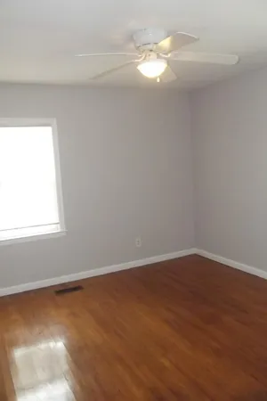 a view of a room with wooden floor and fan