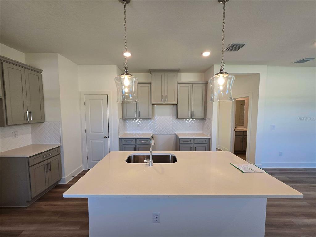 3808 Daybreak Run Loop Spring Hill, FL 34609 - Photo 2 of 14 a large kitchen with a stove a sink a refrigerator a center island and a cabinets