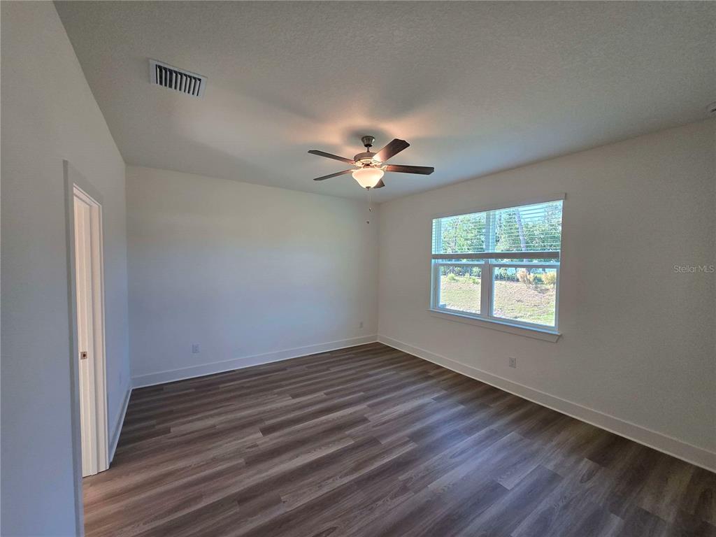 3808 Daybreak Run Loop Spring Hill, FL 34609 - Photo 8 of 14 wooden floor in an empty room with a window