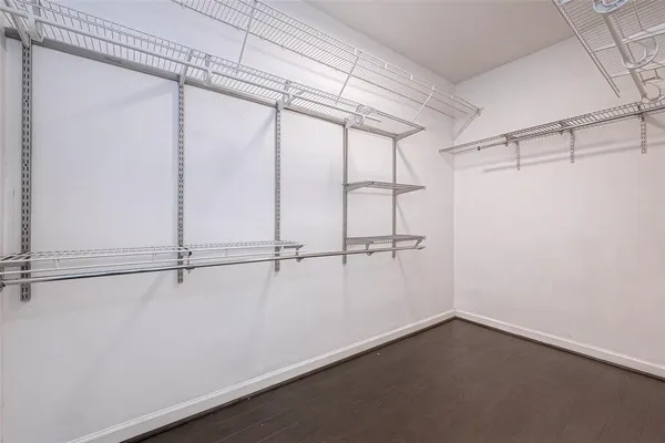 a view of an empty room and chandelier fan