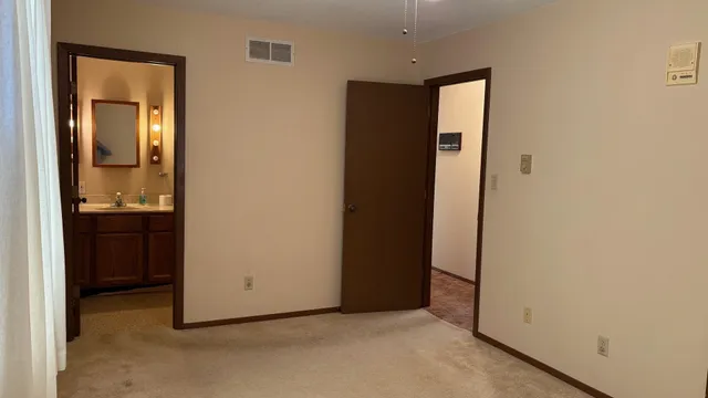an empty room with closet and mirror
