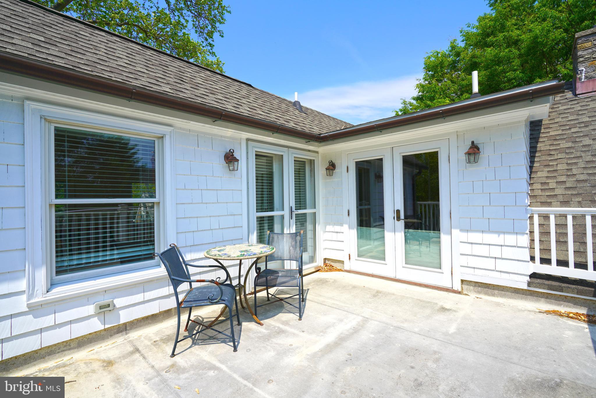 240 2nd Street Lewes, DE 19958 - Photo 76 of 90 a patio with a table and chairs and potted plants