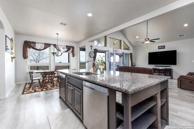 a kitchen with stainless steel appliances granite countertop a refrigerator and a sink