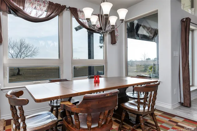 a bedroom with a bed a chandelier and dresser