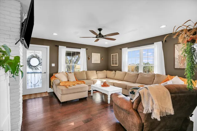 a living room with furniture a flat screen tv and a window