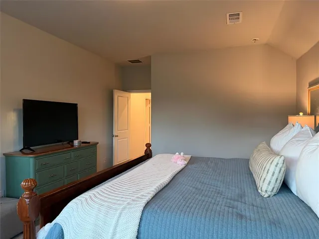 a bedroom with a bed and a dresser next to a window