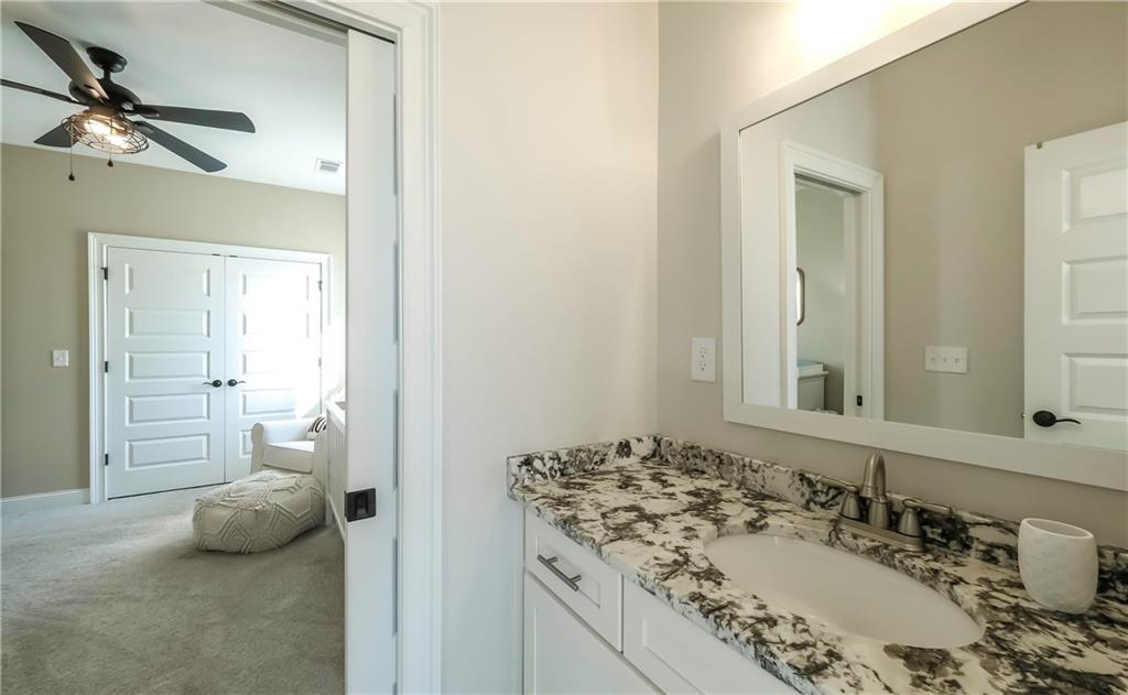 2392 Welcome Road Roopville, GA 30170 - Photo 20 of 65 a bathroom with a granite countertop sink a toilet and a mirror