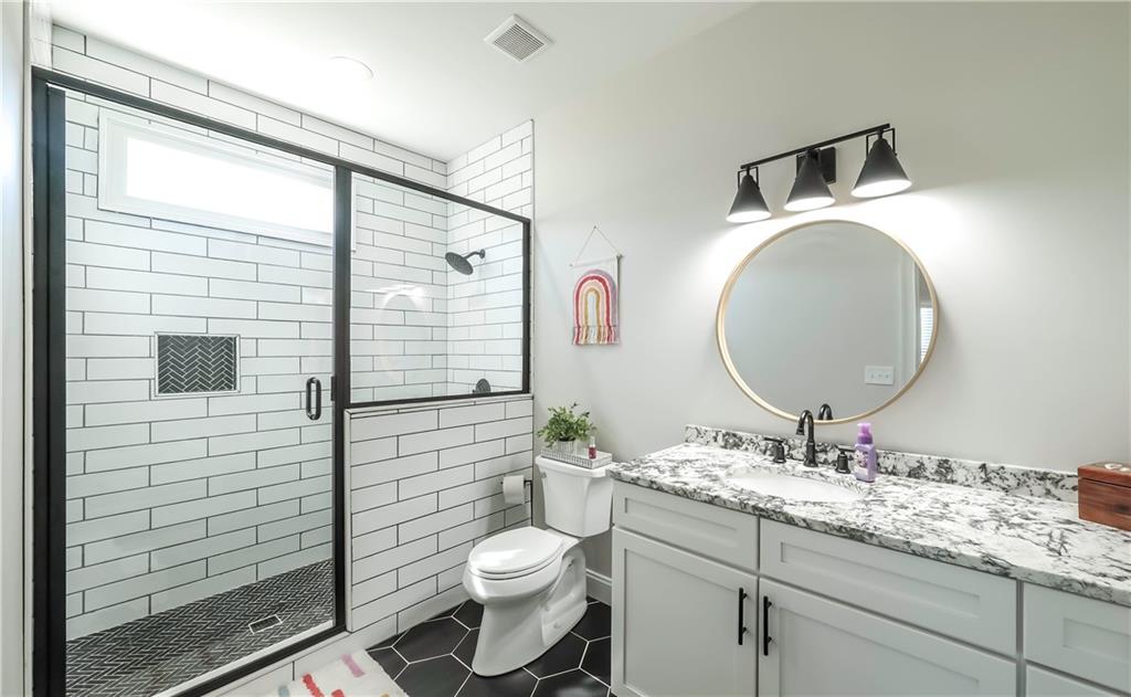 2392 Welcome Road Roopville, GA 30170 - Photo 29 of 65 a bathroom with a toilet a sink and mirror