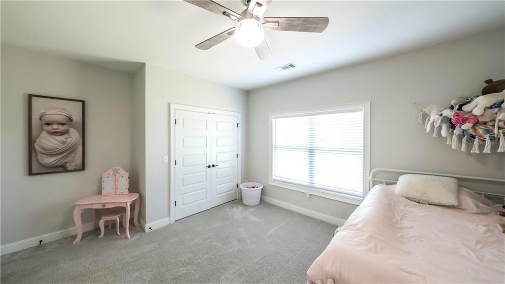 2392 Welcome Road Roopville, GA 30170 - Photo 31 of 65 a spacious bedroom with a bed and a chandelier
