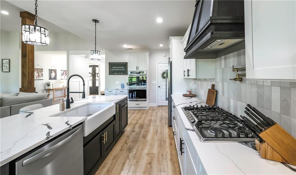 2392 Welcome Road Roopville, GA 30170 - Photo 39 of 65 a kitchen with stainless steel appliances a sink a stove and a wooden floors