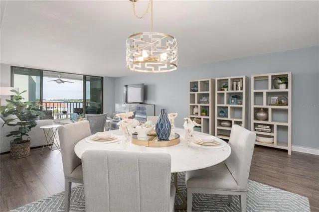 a dining room with wooden floor and large windows