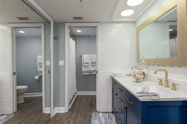 a bathroom with a sink a toilet and shower