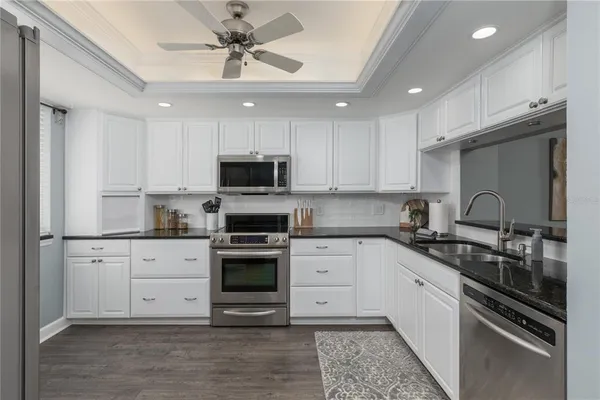 a kitchen with granite countertop a sink stainless steel appliances and cabinets
