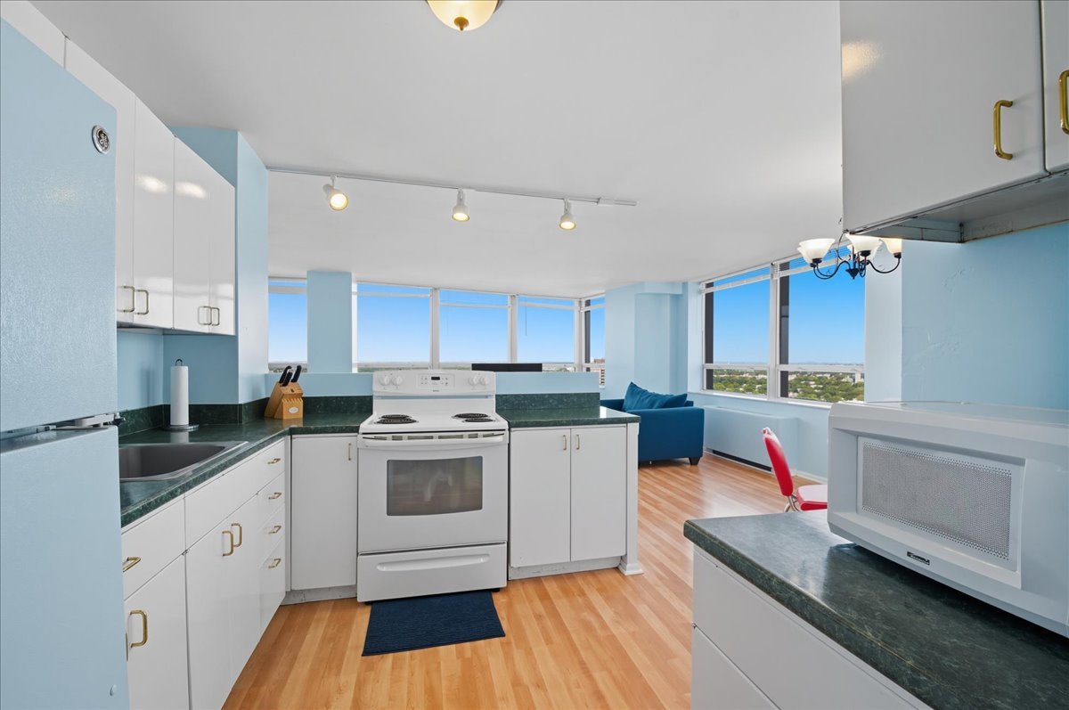 5701 North Sheridan Road, Unit 26B Chicago, IL 60660 - Photo 7 of 18 a kitchen with cabinets a sink and white appliances