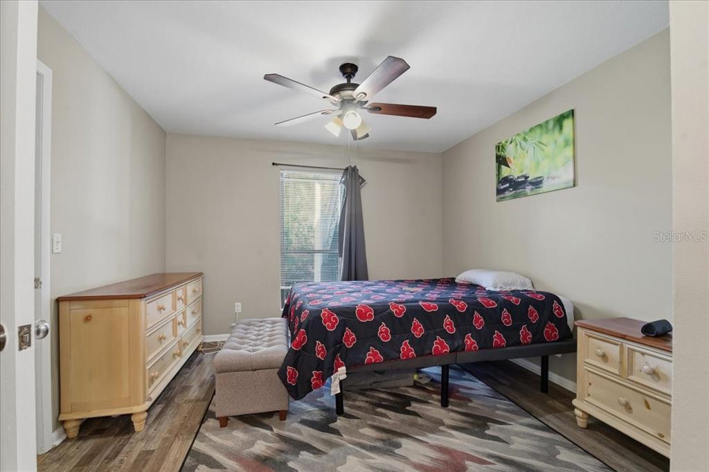 455 Alt 19, Unit 151 Palm Harbor, FL 34683 - Photo 23 of 52 a bedroom with a bed and a chandelier
