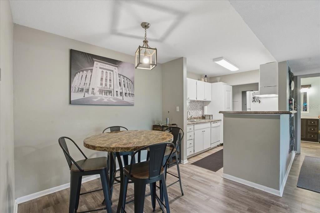 455 Alt 19, Unit 151 Palm Harbor, FL 34683 - Photo 8 of 52 a kitchen with stainless steel appliances granite countertop a dining table chairs and white cabinets