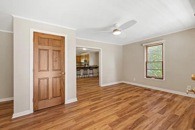 a view of an empty room with window and wooden floor