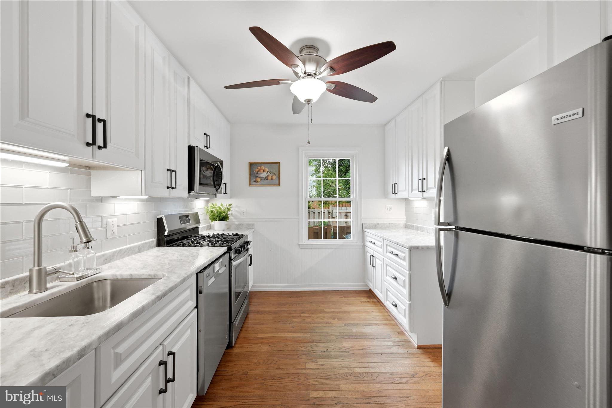 5446 Lighthouse Lane Burke, VA 22015 - Photo 8 of 36 a kitchen with a refrigerator a sink a stove and cabinets