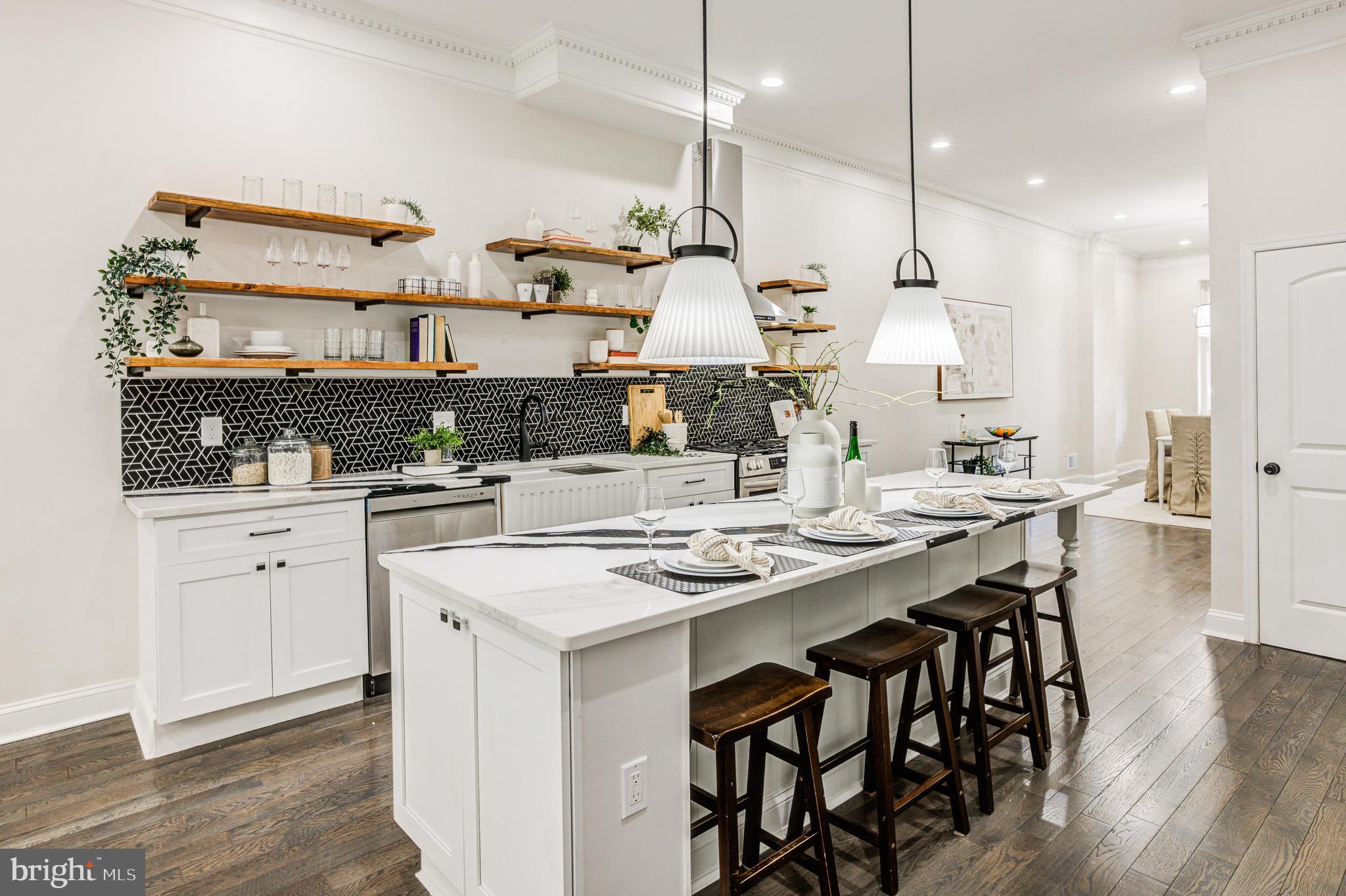 a kitchen with stainless steel appliances kitchen island a wooden floor and white cabinets