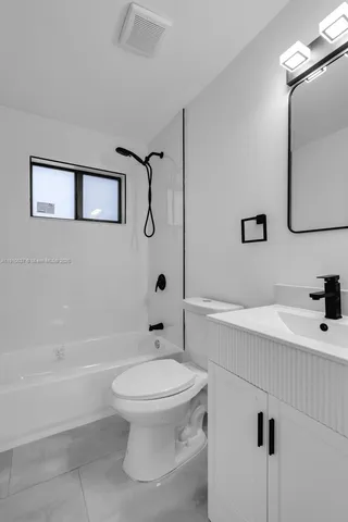 an empty room with ceiling fan and windows