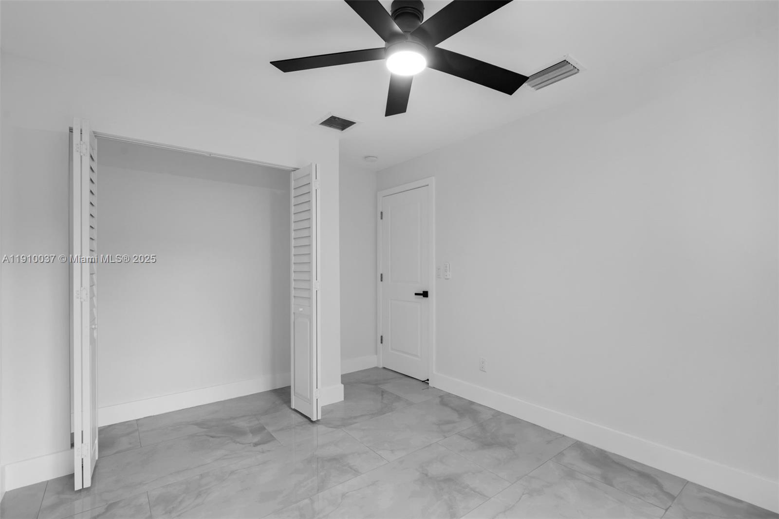 1411 Northwest 40th Street Miami, FL 33142 - Photo 23 of 52 an empty room with chandelier fan