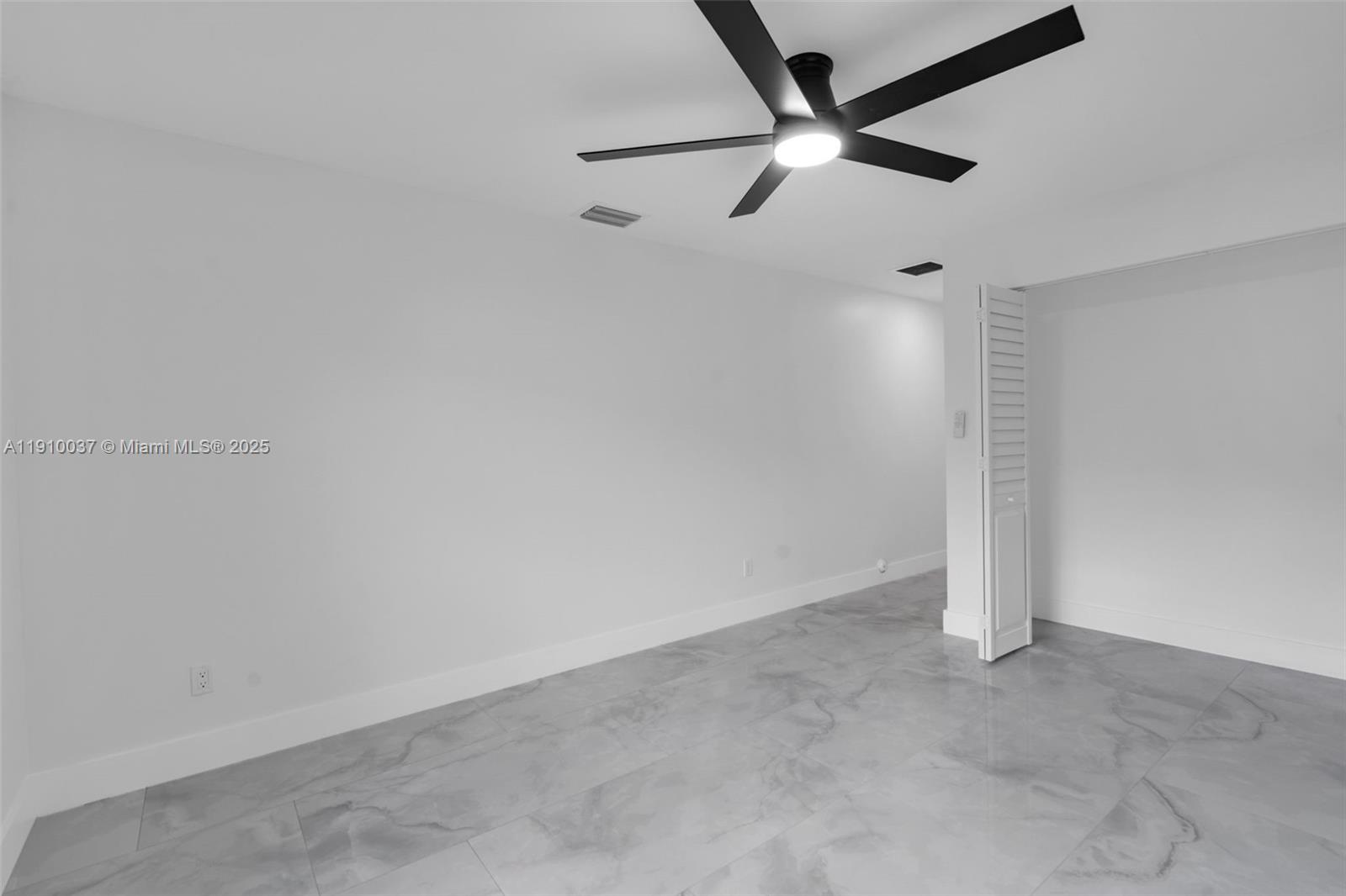 1411 Northwest 40th Street Miami, FL 33142 - Photo 33 of 52 an empty room with a ceiling fan and carpet