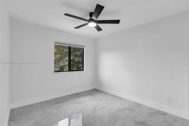 a view of a backyard with plants and large tree