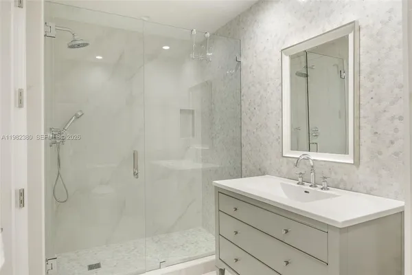 a bathroom with a shower sink vanity and mirror