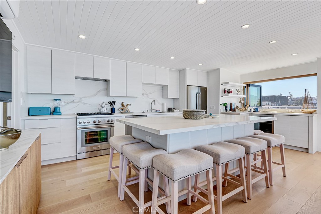 230 40th Street, Unit 3 Manhattan Beach, CA 90266 - Photo 10 of 38 a kitchen with stainless steel appliances a sink a stove a refrigerator cabinets and chairs