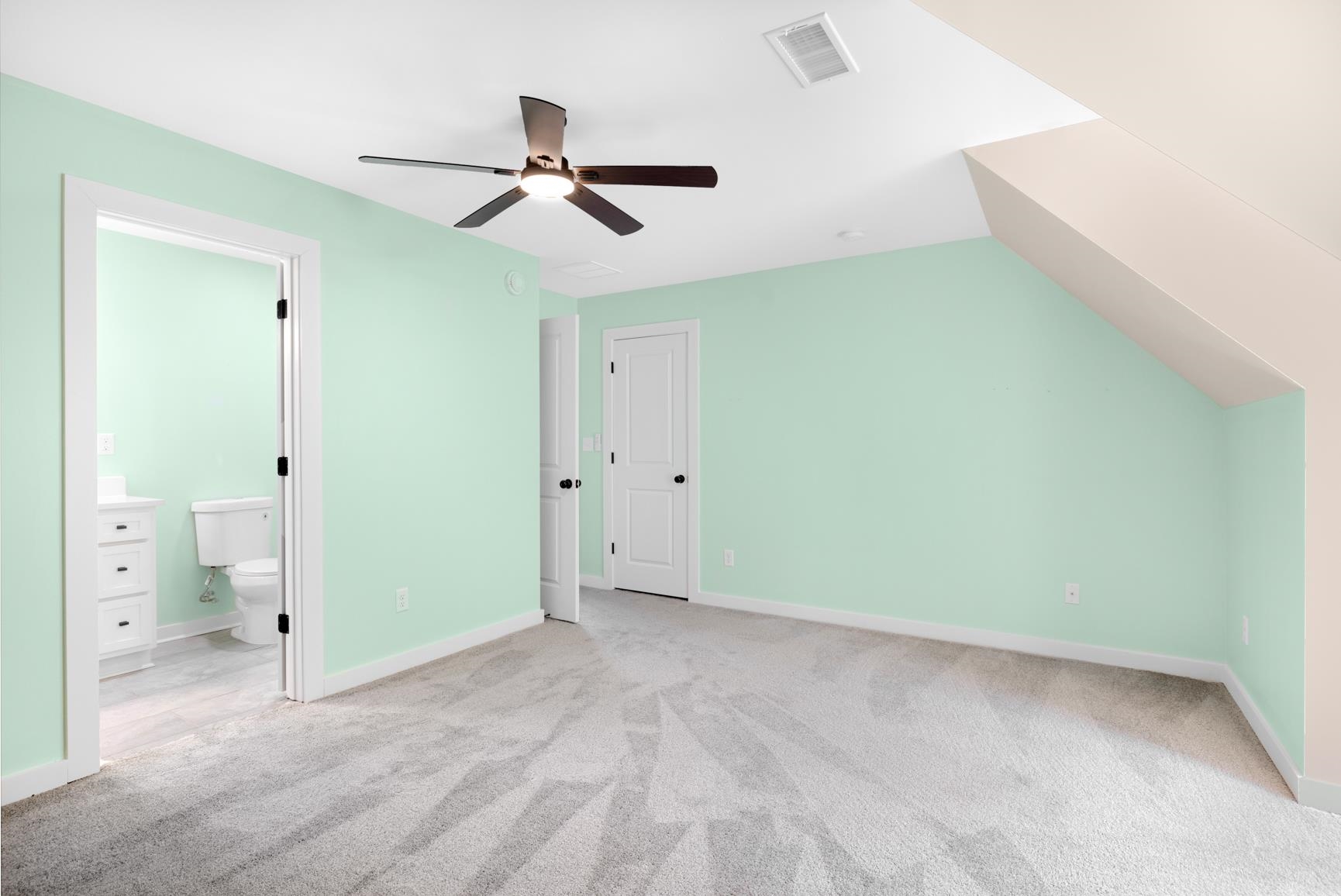 5702 Spring Lake Road Memphis, TN 38135 - Photo 34 of 40 Spacious room with sloped ceiling, light-colored walls, gray patterned carpeting, and a ceiling fan with integrated lighting